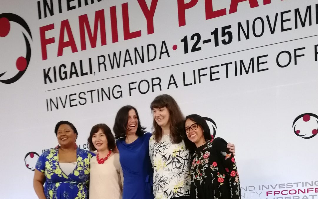 The four pleasure panelists stand together on the stage at ICFP 2018 in front of an ICFP poster.